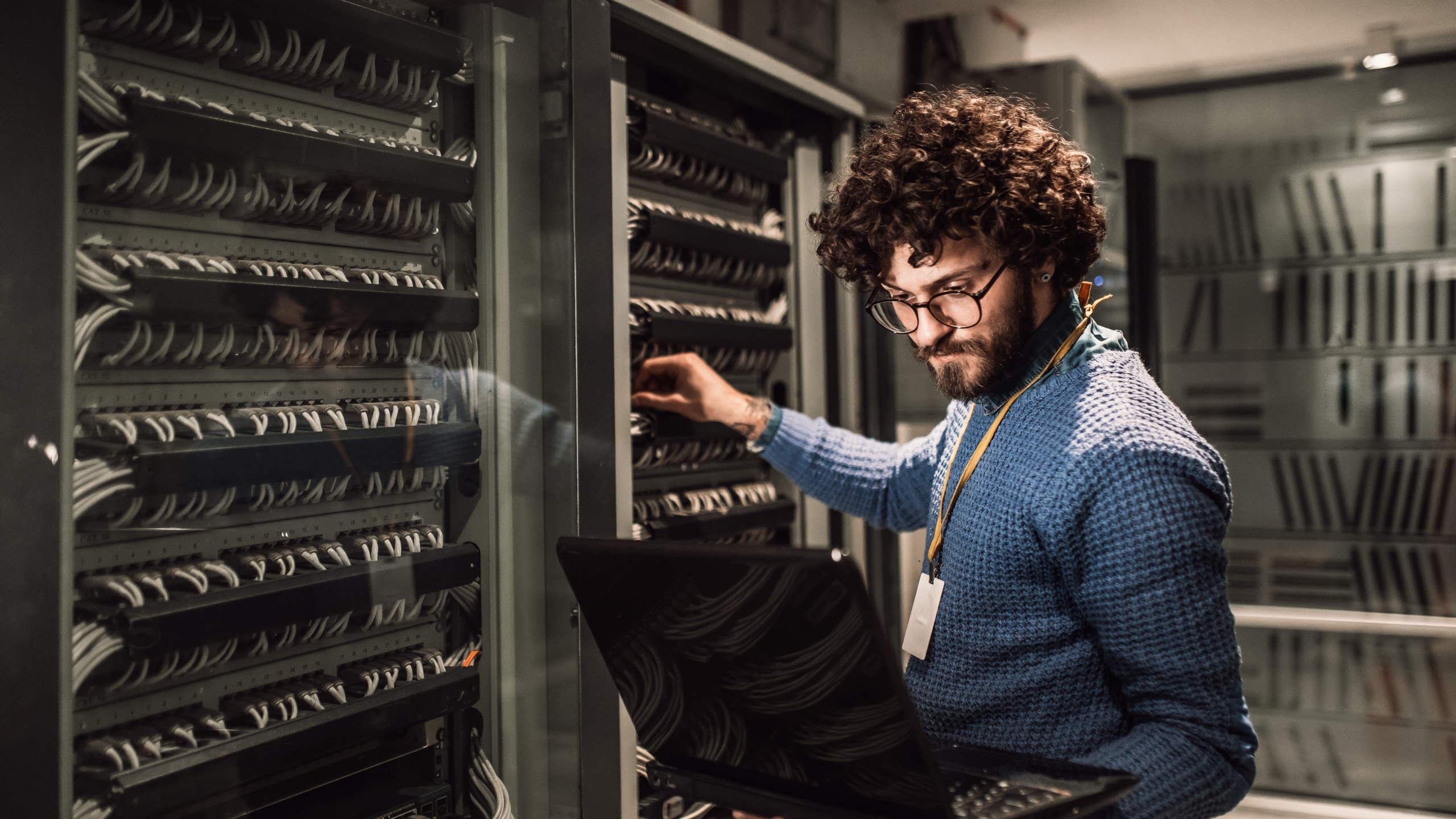 An image of a technology business owner working in his server room