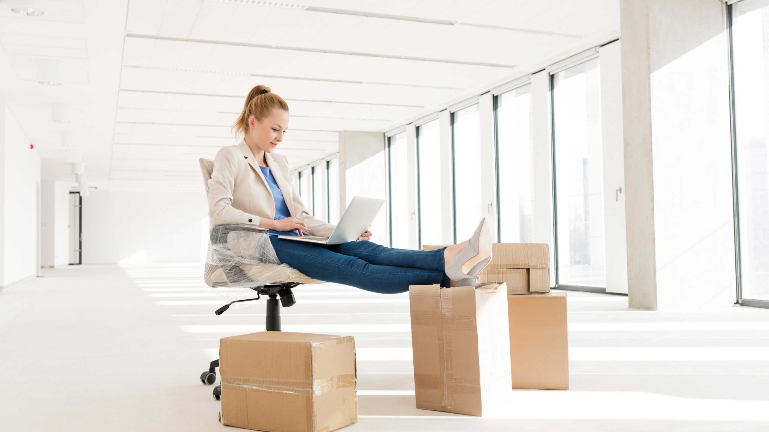 A female business owner in her new office doing work on her computer