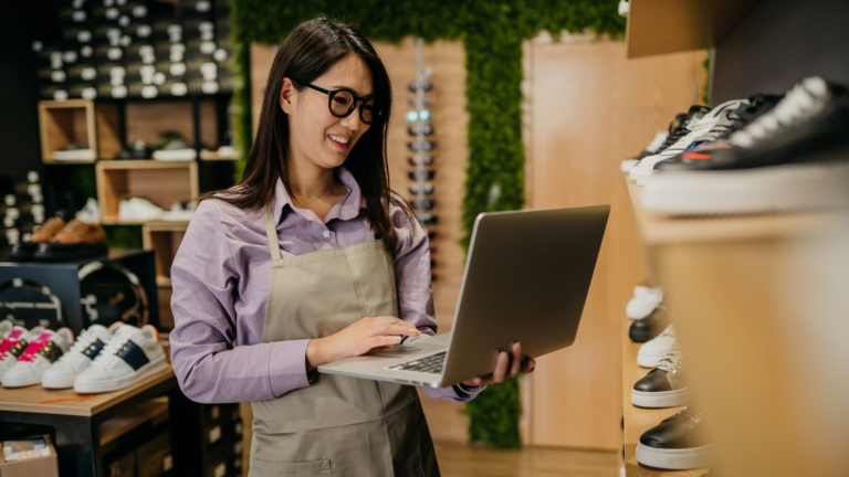 An image of a small retail business owner in Markham who is check on inventory with her computer
