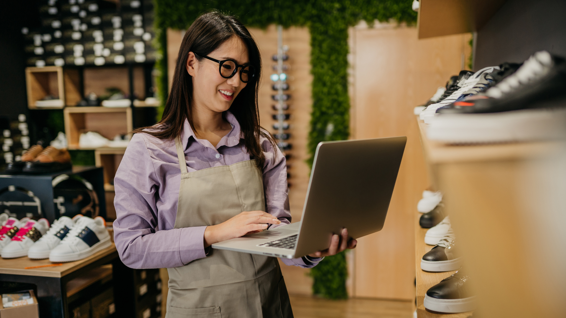 An image of a small retail business owner in Markham who is check on inventory with her computer